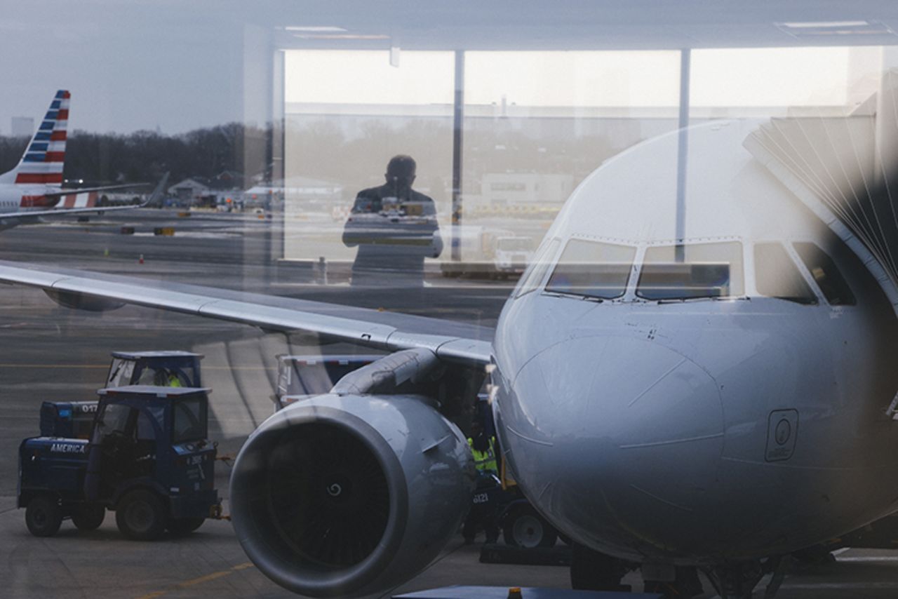 A traveler is reflected in a window at LaGuardia Airport (LGA) in New York, U.S., on Thursday, Dec. 24, 2020.