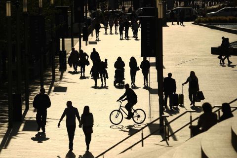 People are silhouetted against the late summer sun in Liverpool, England on September 18, after the British government imposed fresh restrictions on the city following a rise in coronavirus cases.