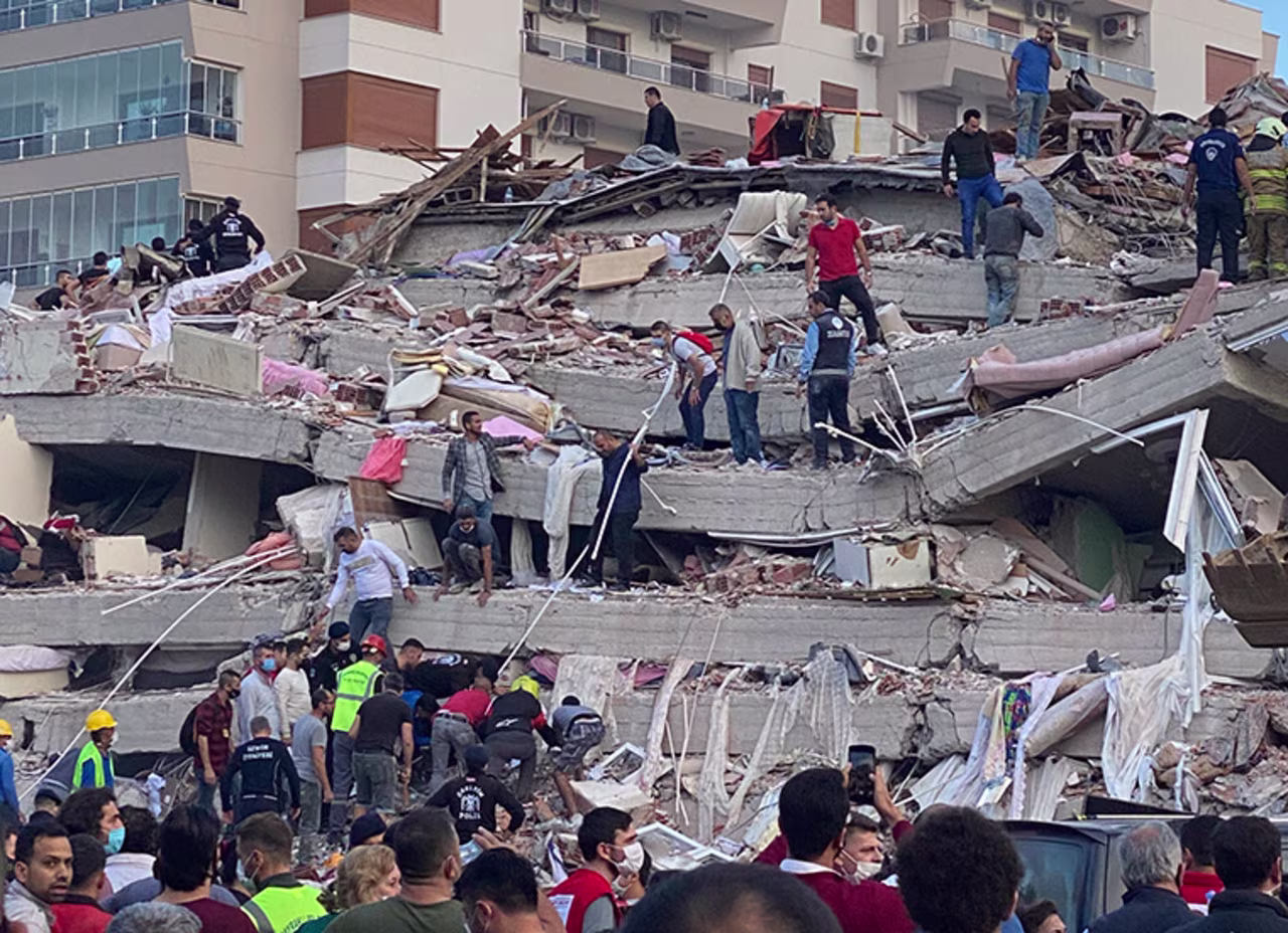 Rescue workers and local people try to save residents trapped in the debris of a collapsed building, in Izmir, Turkey, Friday, Oct. 30, 2020. 