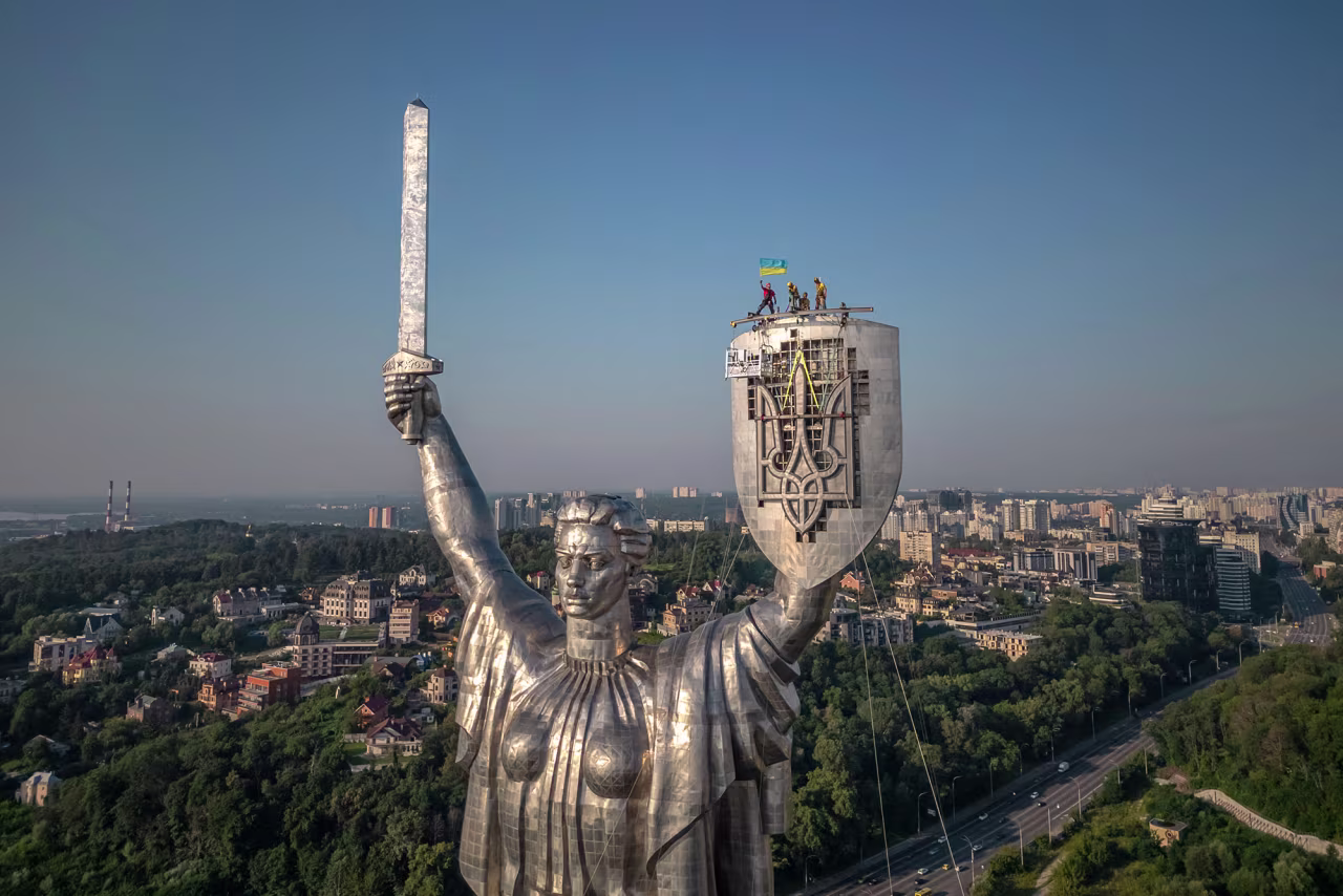 Steeplejacks wave the Ukrainian flag after finishing installing the coat of arms of Ukraine on the shield of the 62 metre Motherland Monument in Kyiv, Ukraine, on August 6.