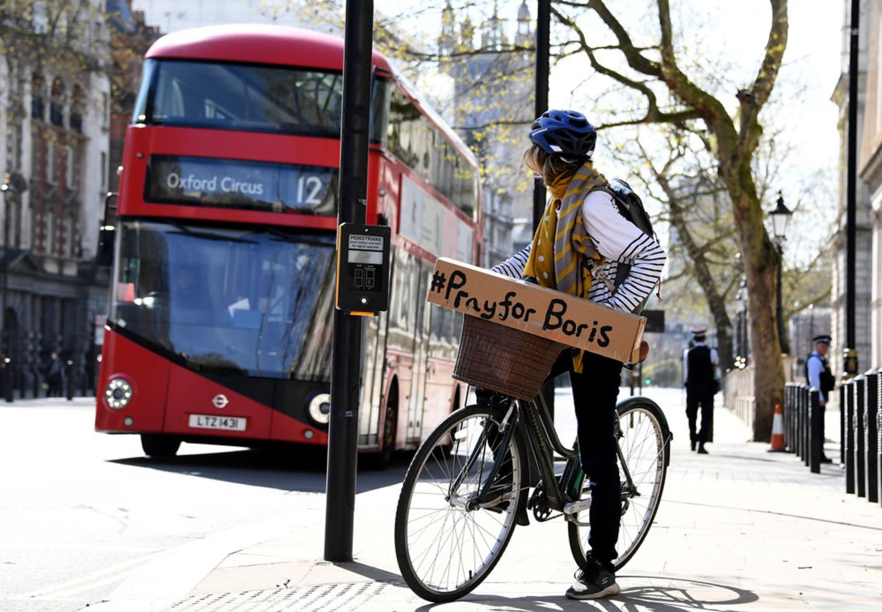 A woman shows a sign on her bicycle as British Prime Minister Boris Johnson is in intensive care fighting the coronavirus in London, Tuesday, April 7. 