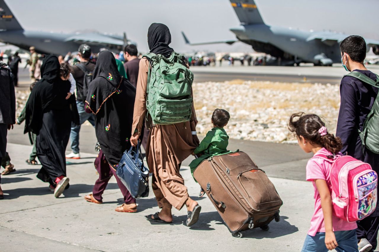 In this photo provided by the U.S. Marine Corps, families walk towards their flight during ongoing evacuations at Hamid Karzai International Airport, in Kabul, Afghanistan on August 24.