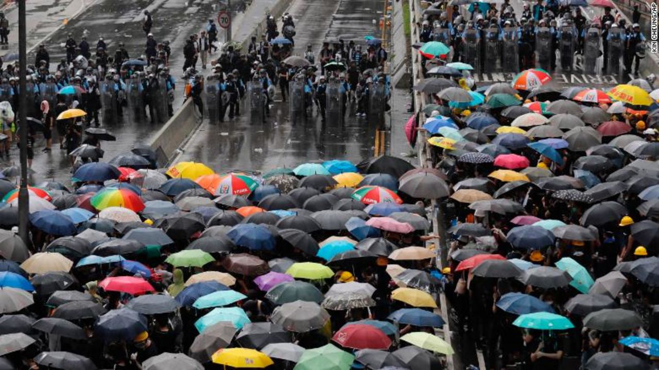 Protesters holding umbrellas face off police officers in anti-riot gear in Hong Kong on Monday, July 1, 2019.