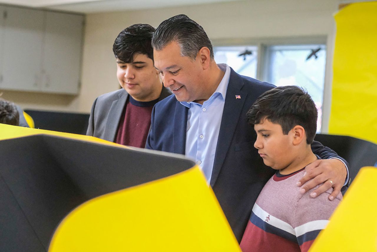 Padilla, center, with his sons Roman, left, and Diego casts his ballot on Tuesday, November 8, in Pacoima, California. 