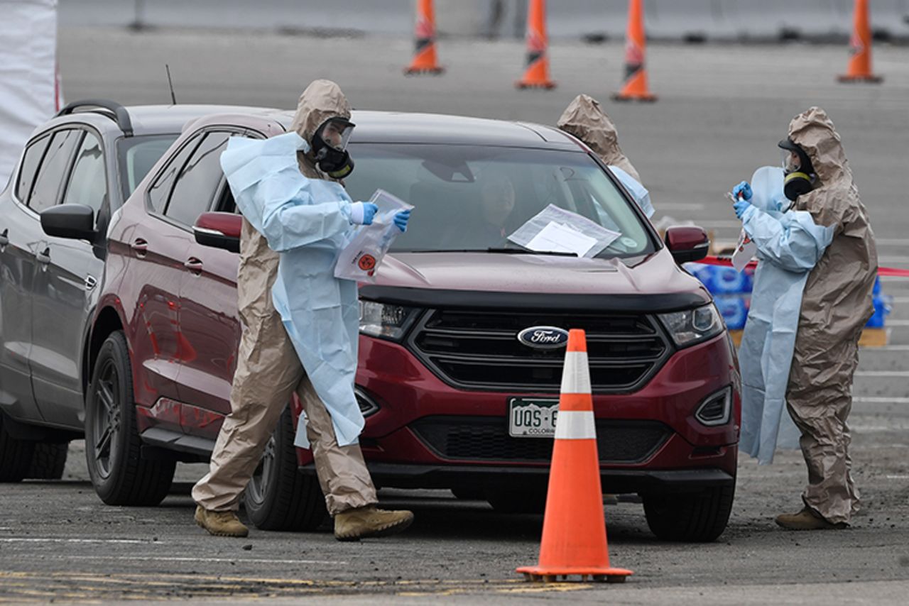 Colorado National Guard members assist the Colorado Department of Public Health and Environment during a free, drive-up testing site for coronavirus in the parking lot of the Denver Coliseum on March 14. 