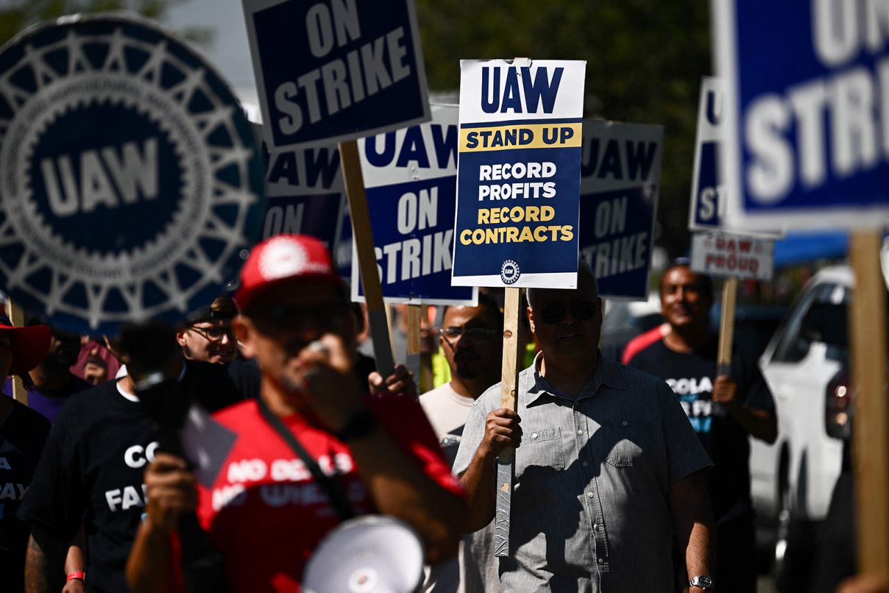 Labor supporters and members of the United Auto Workers union (UAW) Local 230 march along a picket line during a strike outside of the Stellantis Chrysler Los Angeles Parts Distribution Center in Ontario, California, on September 26.