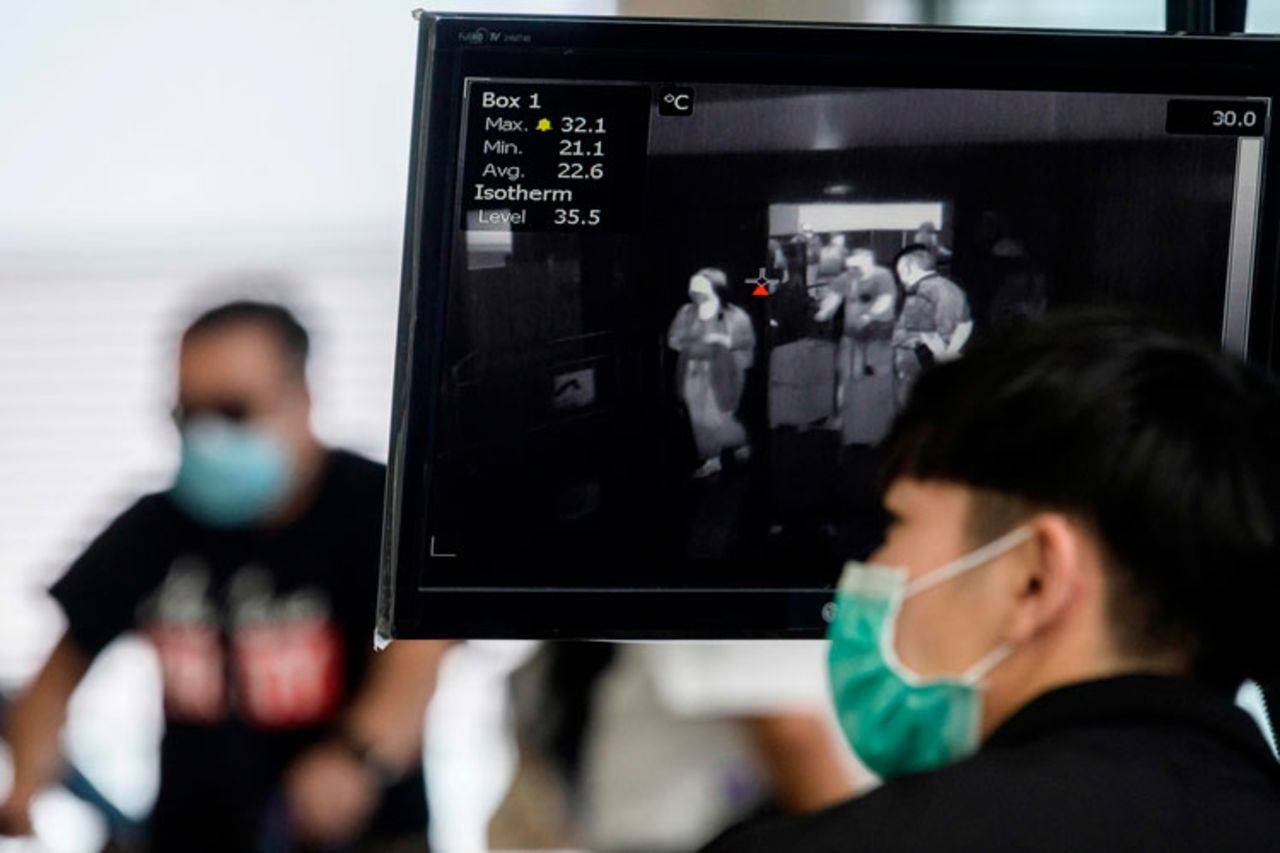 A airport employee worker monitors a thermal screening display as passengers enter Hong Kong's Chek Lap Kok International Airport on March 10.