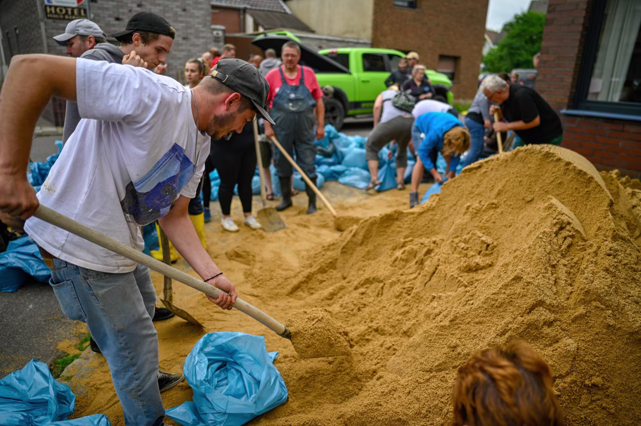 Residents fill bags with sand to protect against flooding on July 16 in Erftstadt, Germany. 