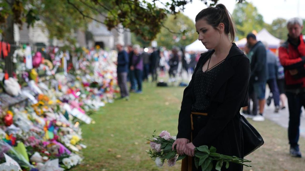 A woman stands near the memorial at the botanical gardens in Christchurch.