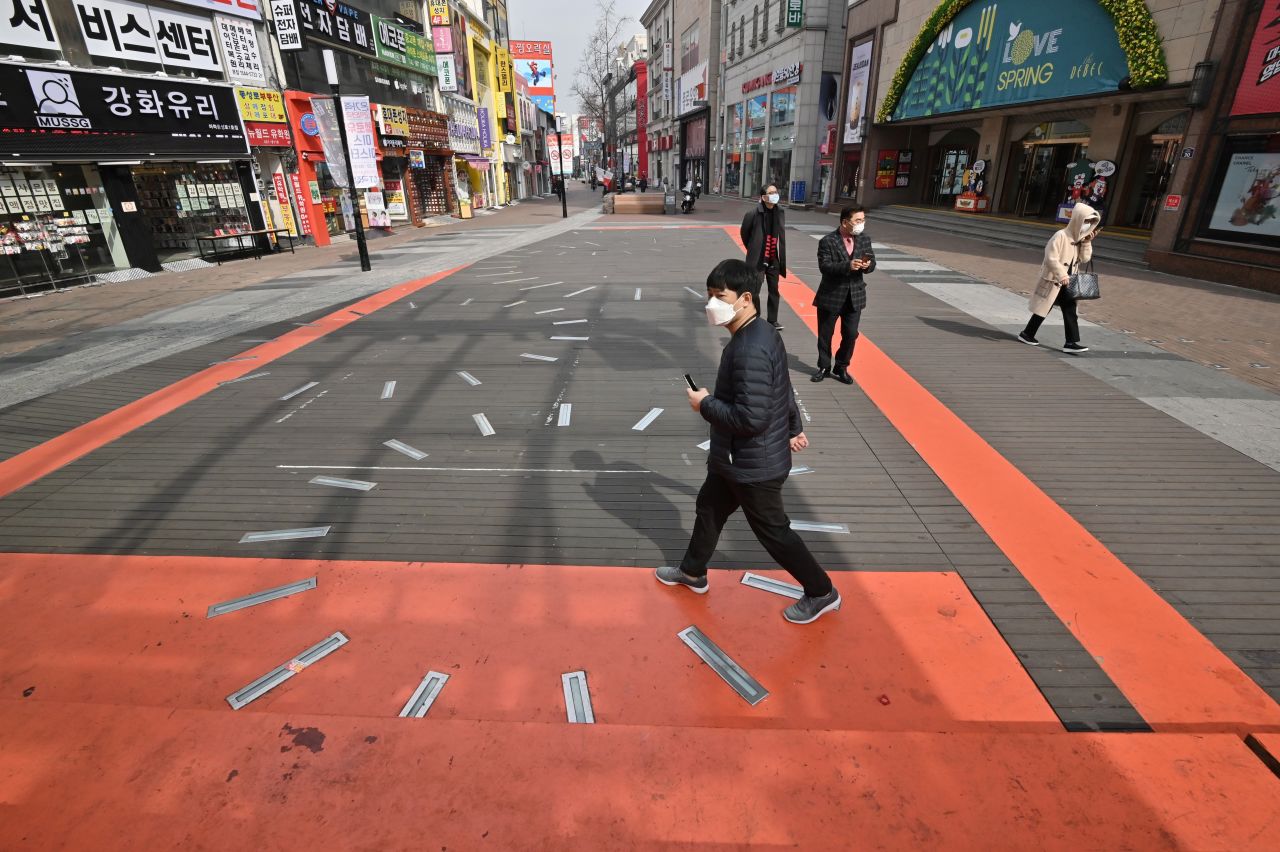 Pedestrians wearing face masks walk on the street at Dongseongro shopping district in the southeastern city of Daegu.