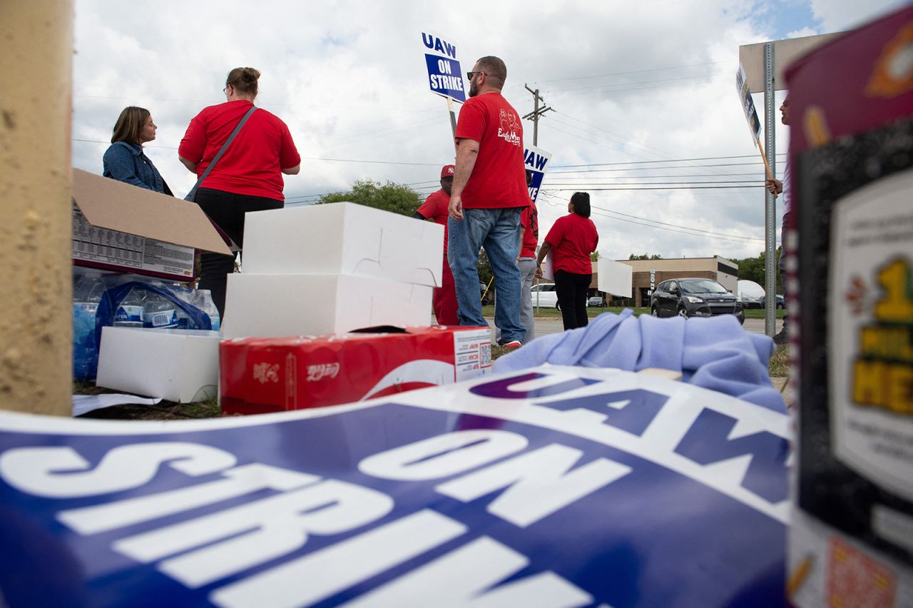 Members of the United Auto Workers union walk the picket line in front of the Ford Michigan assembly plant in Wayne, Michigan today.