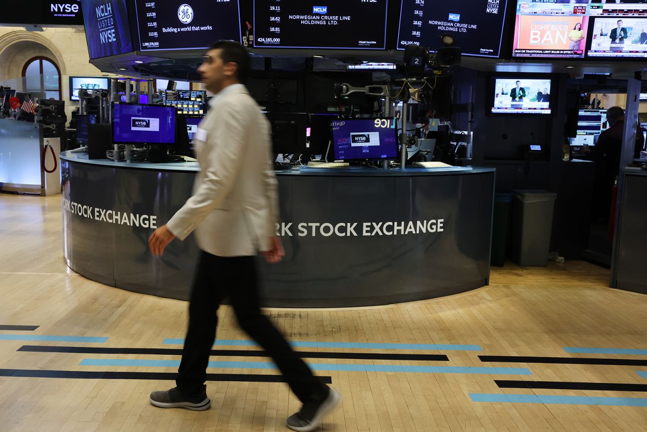 People walk on the floor of the New York Stock Exchange on August 2.