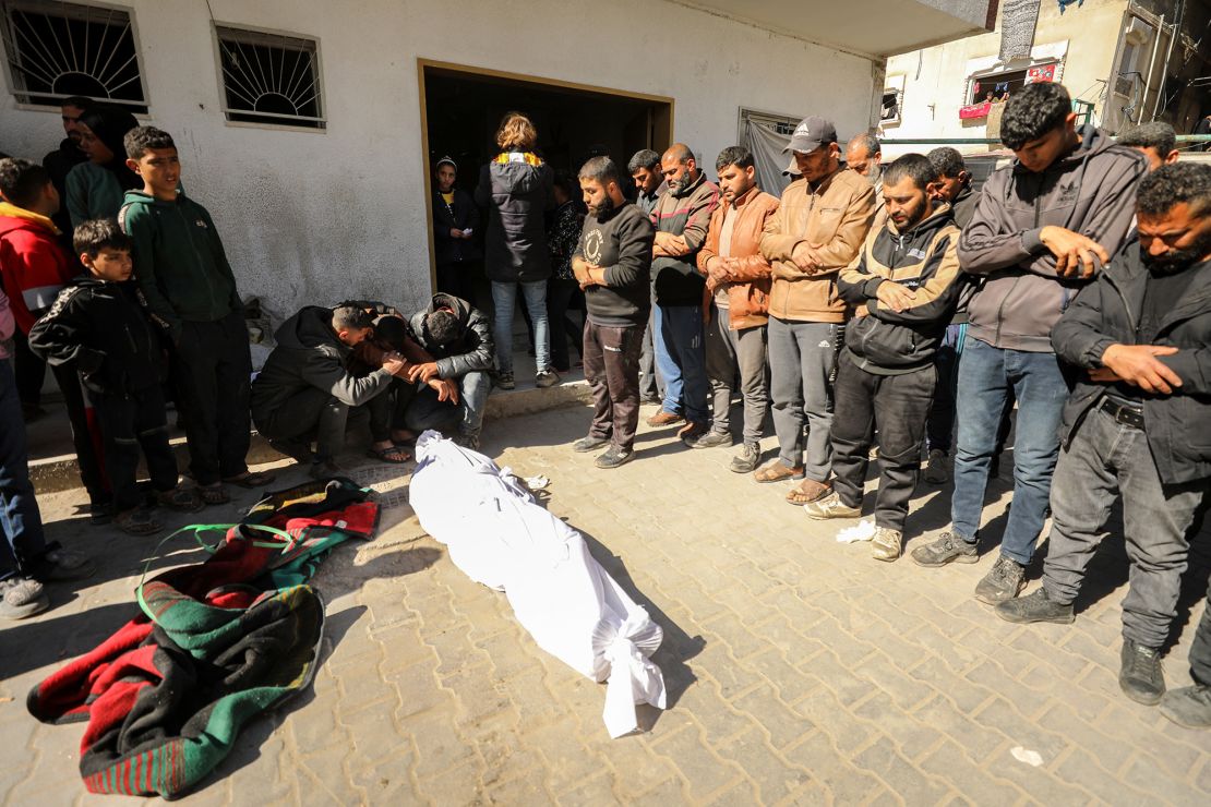 Palestinians mourn near a body at Kamal Edwan Hospital in Beit Lahia, northern Gaza, on February 29, after Israeli soldiers allegedly opened fire at Gaza residents who rushed towards trucks loaded with humanitarian aid.