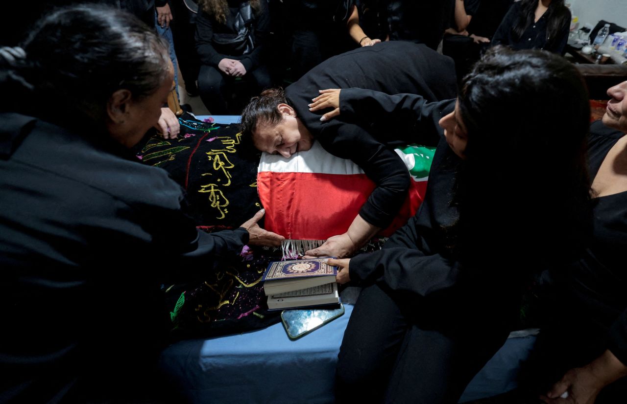 The mother of Issam Abdallah, a Reuters videojournalist who was killed in southern Lebanon, mourns over her son's body during his funeral in Al Khiyam, Lebanon, on October 14.