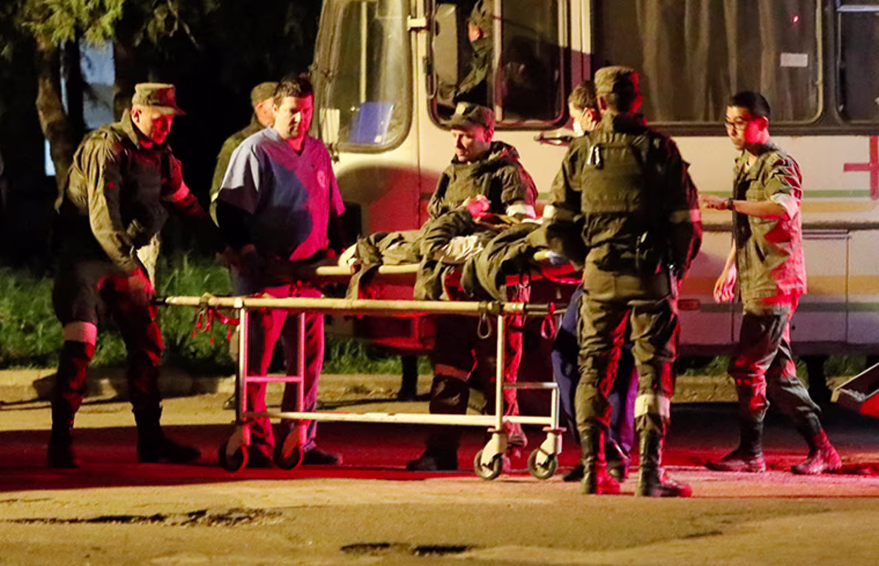 A wounded service member of Ukrainian forces from the besieged Azovstal steel mill in Mariupol is transported on a stretcher out of a bus, in Novoazovsk, on  May 16.