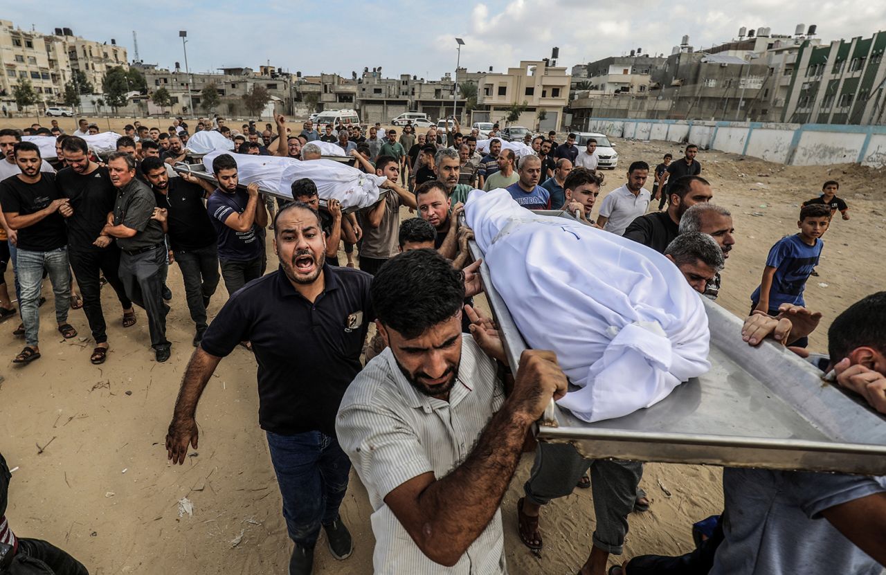 People carry bodies of Palestinians killed during an Israeli airstrike prior to their burial in Khan Younis, Gaza, on October 11. 