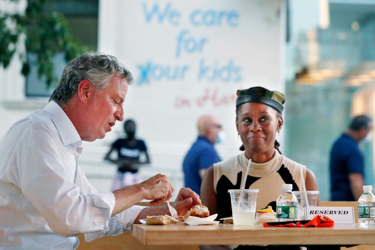 New York Mayor Bill de Blasio, left, dines with his wife Chirlane McCray in an outdoor booth at Melba's restaurant in Harlem on the first day of the Phase 2 reopening of the city during the?coronavirus pandemic Monday, June 22, 2020, in New York. (AP Photo/