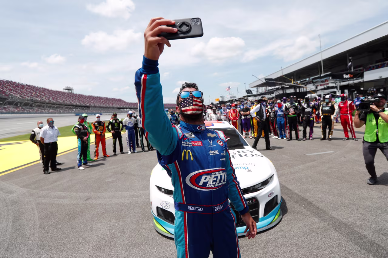 Driver Bubba Wallace takes a selfie with himself and other drivers that pushed his car to the front in the pits of the Talladega Superspeedway prior to the start of the NASCAR Cup Series auto race at the Talladega Superspeedway in Talladega Alabama, on Monday, June 22.
