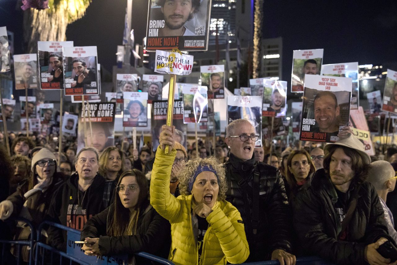 People hold signs and photos of hostages as they are taking part in a rally calling for the release of hostages held by Hamas in Gaza on February 3, in Tel Aviv, Israel. 