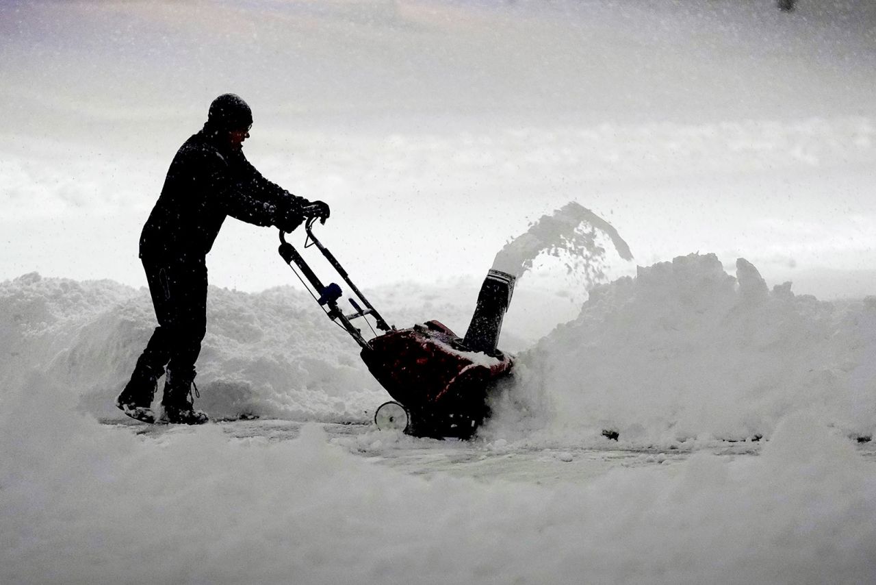 A local resident clears overnight snow from a driveway on Tuesday in Urbandale, Iowa. 