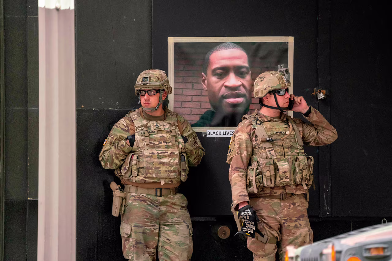 California National Guard soldiers stand near a portrait of George Floyd during a demonstration in downtown Los Angeles, on June 6.