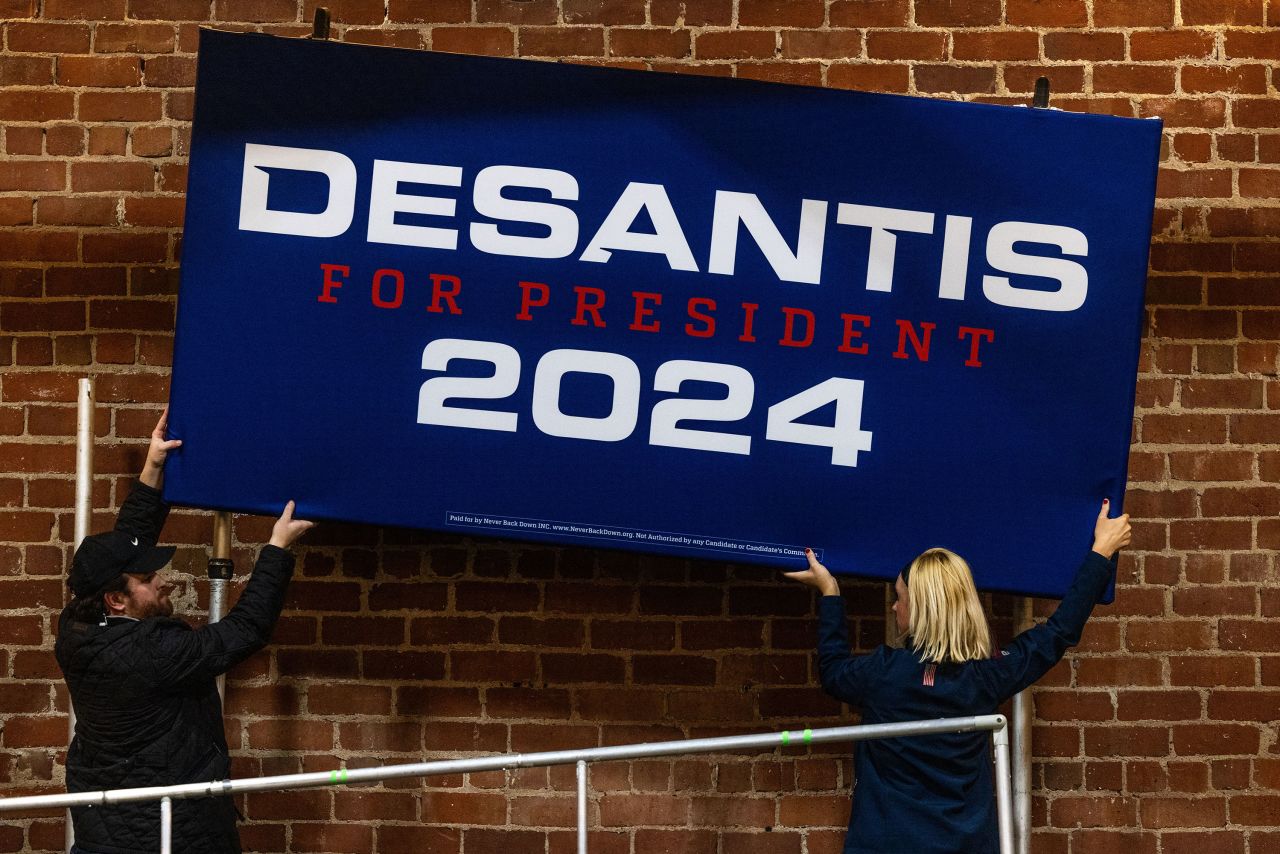 Campaign employees remove a sign for Republican presidential candidate Ron DeSantis following a campaign event in Davenport, Iowa, on Saturday.