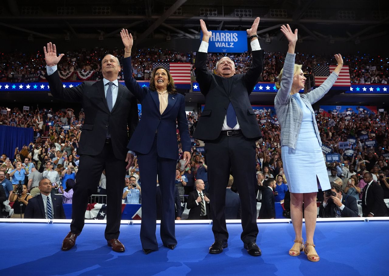 Second gentleman Doug Emhoff,  Vice President Kamala Harris, Minnesota Gov. Tim Walz and his wife Gwen Walz wave to supporters at the end of the campaign rally