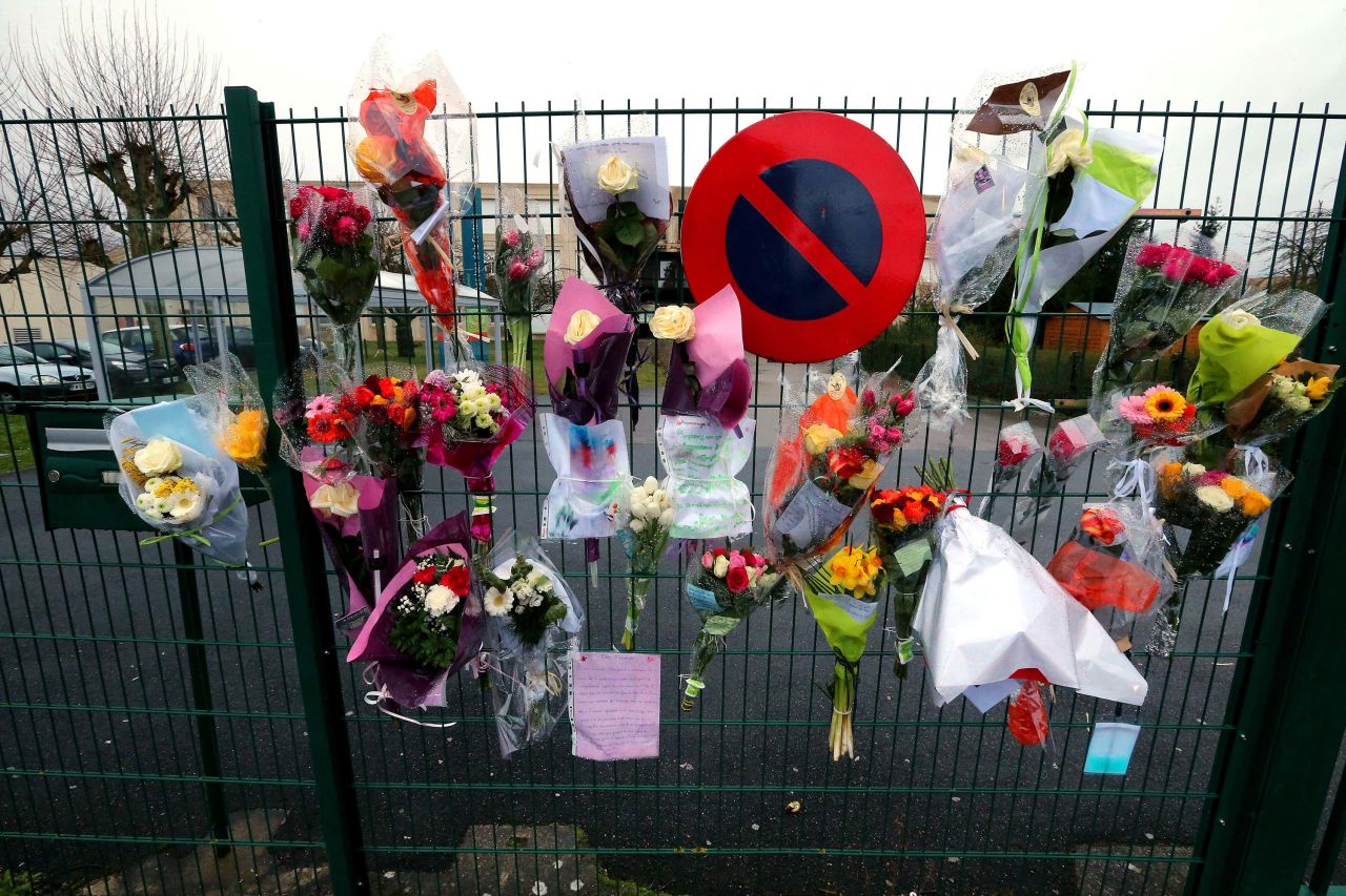 Flowers and messages are hung at the fence of a high school in Crepy-en-Valois, France, on March 2, in tribute to a teacher who died from the?coronavirus.