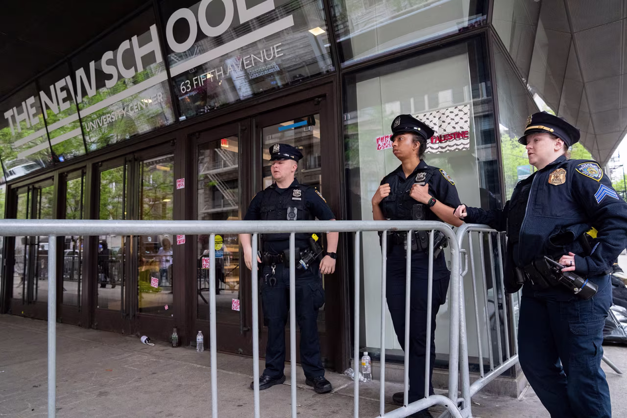 Police officers stand guard outside of The New School in New York on Friday.
