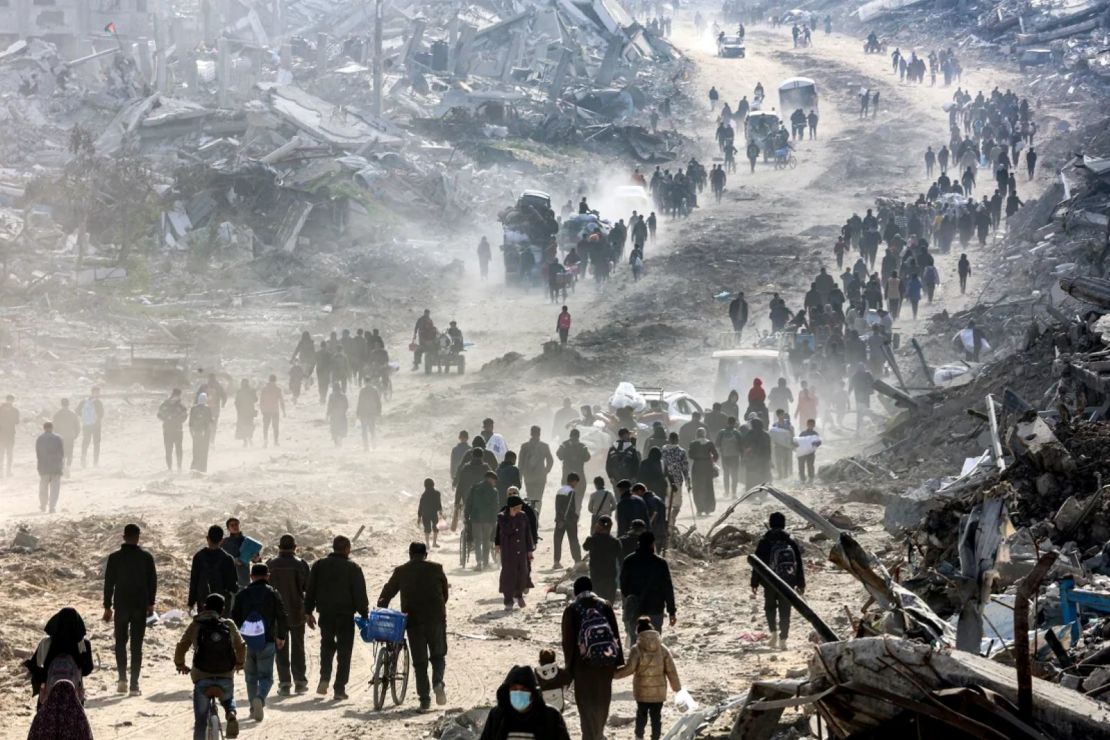 La gente camina entre los escombros de edificios colapsados en el norte de Gaza.