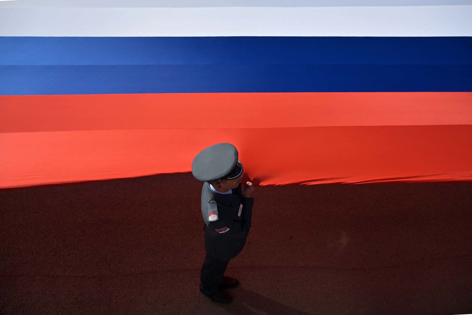 A soldier holds a giant Serbian flag during a military parade in the country’s capital of Belgrade on Saturday, September 20.