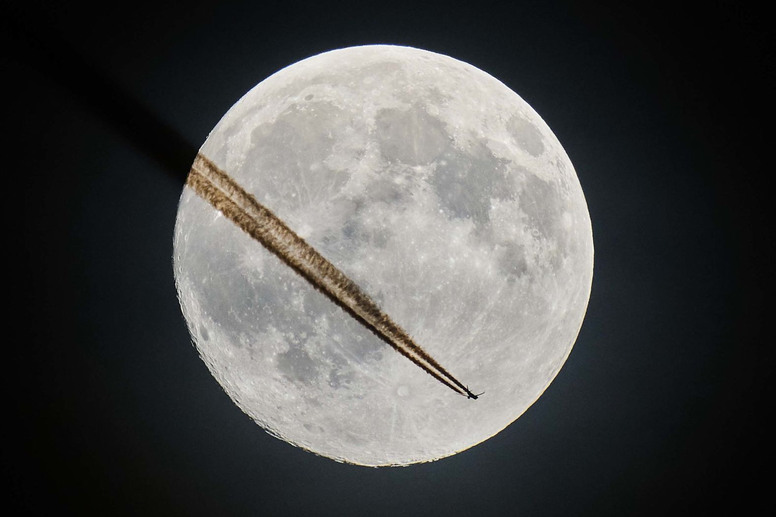An aircraft is seen in front of the moon as it flies over Frankfurt, Germany, on Tuesday, November 4.
