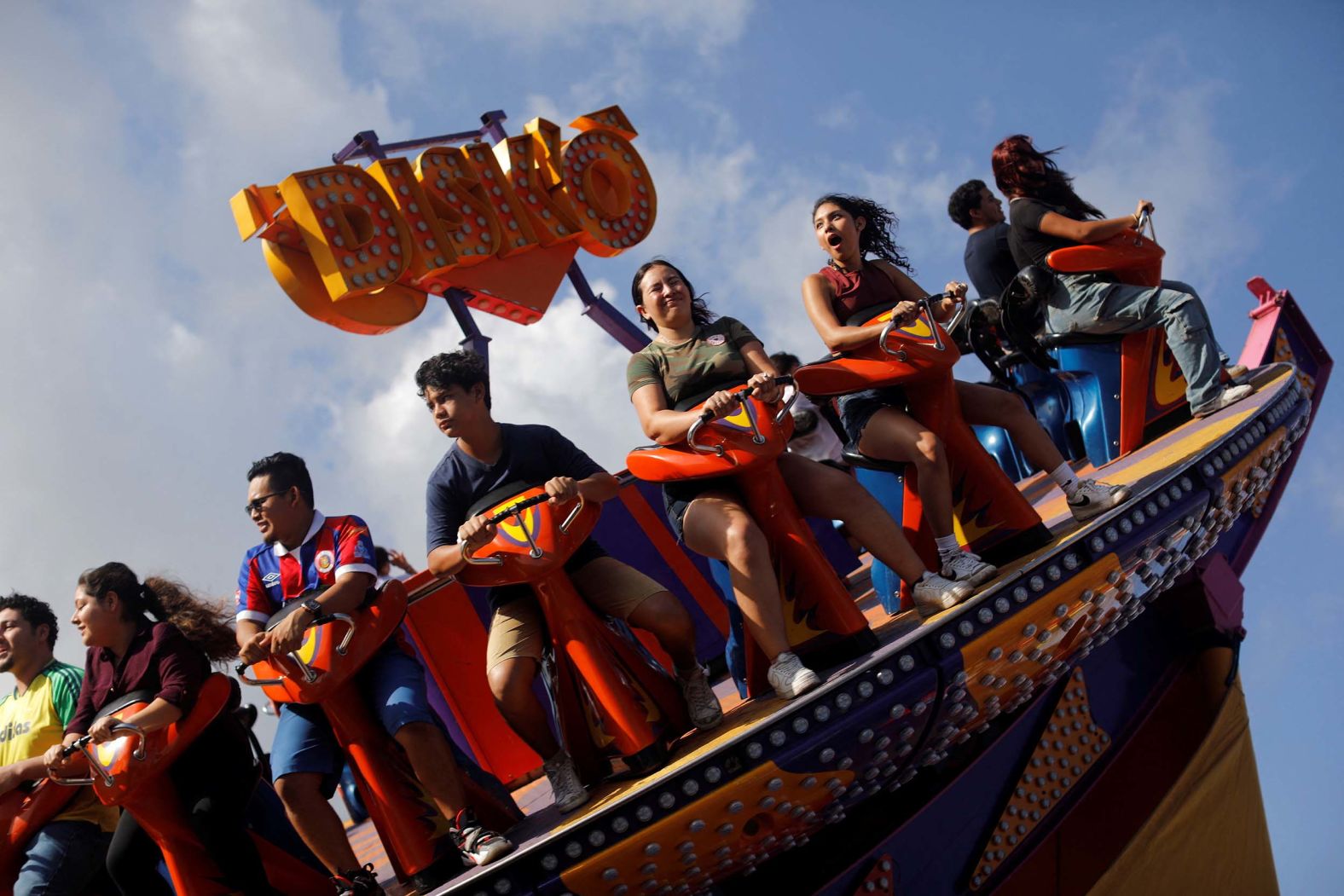 People enjoy a fair ride in San Salvador, El Salvador, on Thursday, August 7.