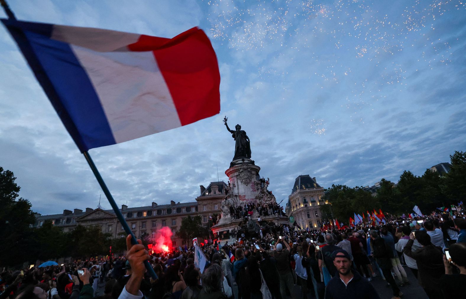 A French flag is waved during an election night rally in Paris’ Place de la République on Sunday, July 7. A left-wing alliance won the most seats in the French parliament, thwarting the far right in a stunning result to <a href="index.php?page=&url=https%3A%2F%2Fwww.cnn.com%2F2024%2F07%2F07%2Feurope%2Ffrance-election-second-round-result-intl%2Findex.html">Sunday’s second-round vote</a>.