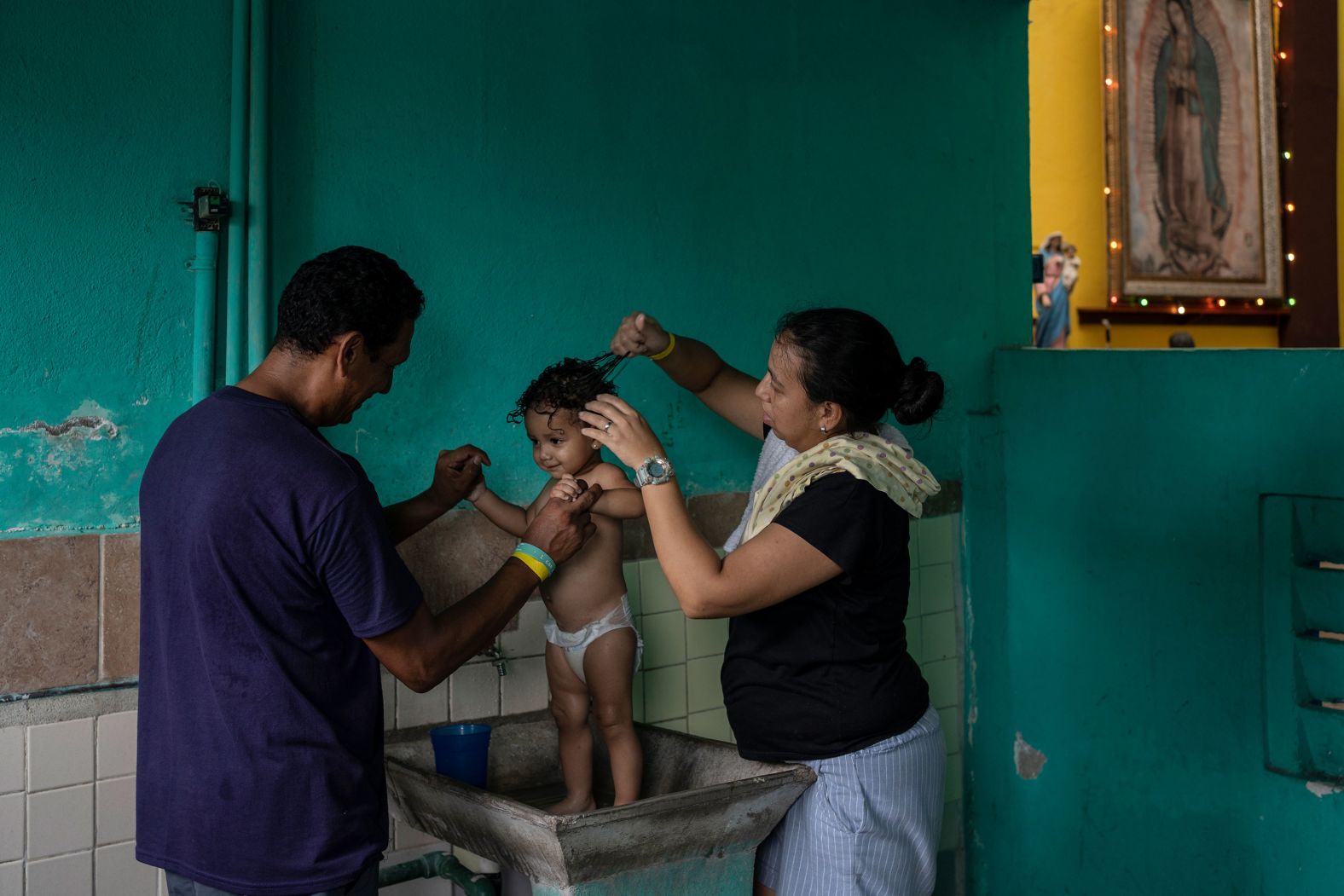 Venezuelan migrants Hernán Sánchez and Rosana Mercado bathe their daughter inside a shelter in Villahermosa, Mexico, on Friday, June 7. After the head of Mexico's immigration agency ordered a halt to deportations in December, migrants have been left in limbo as authorities round up migrants across the country and dump them in the southern Mexican cities of Villahermosa and Tapachula.