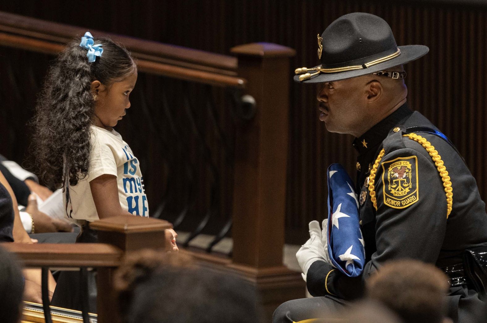 A member of the DeKalb County Police honor guard hands a flag to the daughter of police officer David Rose during Rose's funeral in Atlanta on Friday, August 22. Rose was killed while responding to <a href="index.php?page=&url=https%3A%2F%2Fwww.cnn.com%2F2025%2F08%2F09%2Fus%2Fatlanta-cdc-emory-university-shooting-hnk">a shooting earlier this month</a> on the campus of the Centers for Disease Control and Prevention. He was 33.