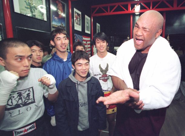 Foreman jokes around with fans following a workout at a gym in Tokyo in 1996.