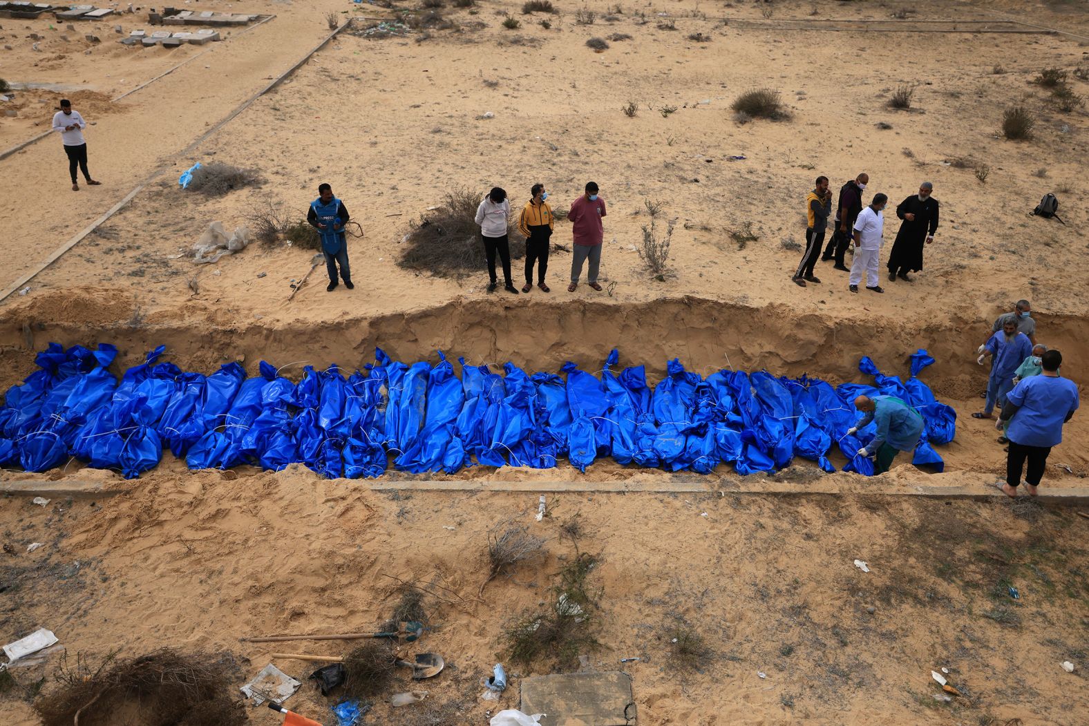 Palestinians bury bodies in a mass grave in the Khan Younis cemetery in southern Gaza on November 22. The remains, which bore only numbers, had come from the Indonesian and Al-Shifa hospitals in northern Gaza, according to members of the committee at the burial site.