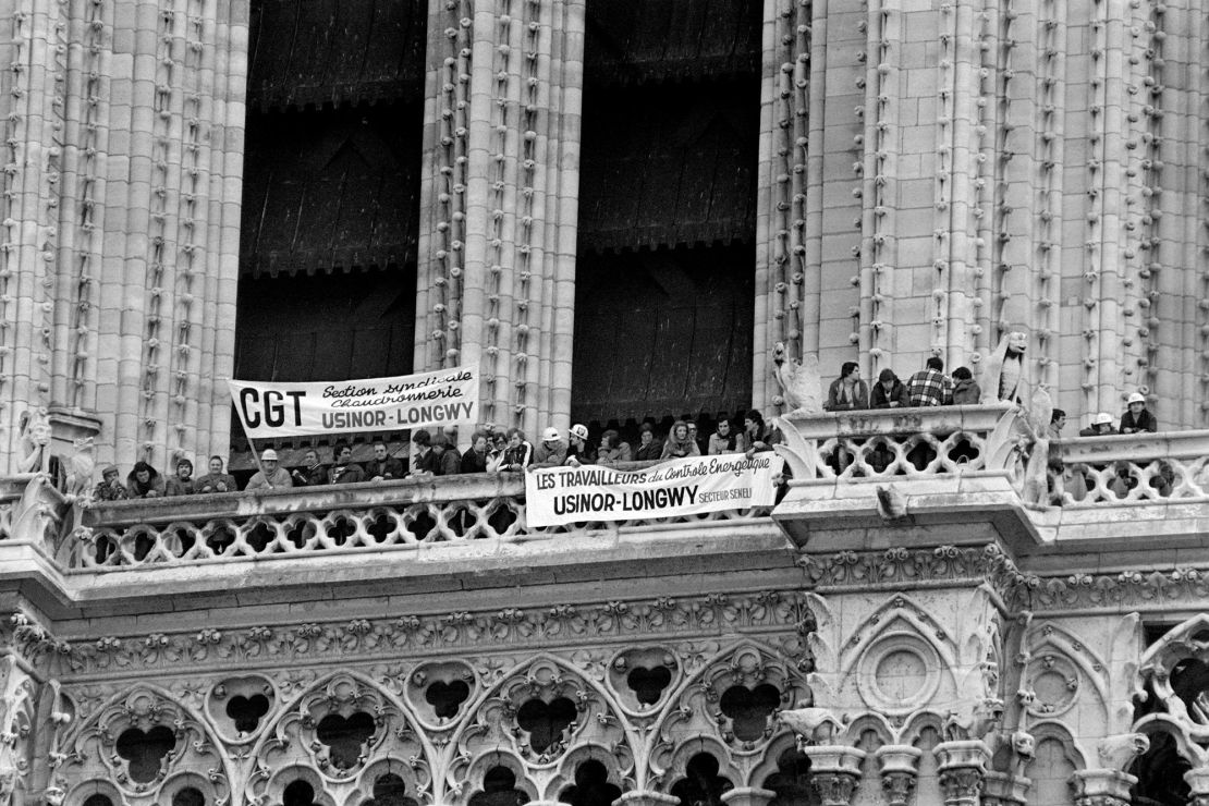 Unionists and steelworkers hang banners from Notre Dame during protests against job cuts and factory closures in the steel industry.