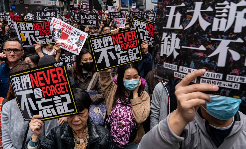 Pro-democracy supporters hold placards as they take part in a New Year's Day rally on Wednesday, January 1 in Hong Kong.