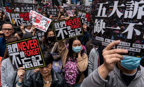Pro-democracy supporters hold placards as they take part in a New Year's Day rally on Wednesday, January 1 in Hong Kong.