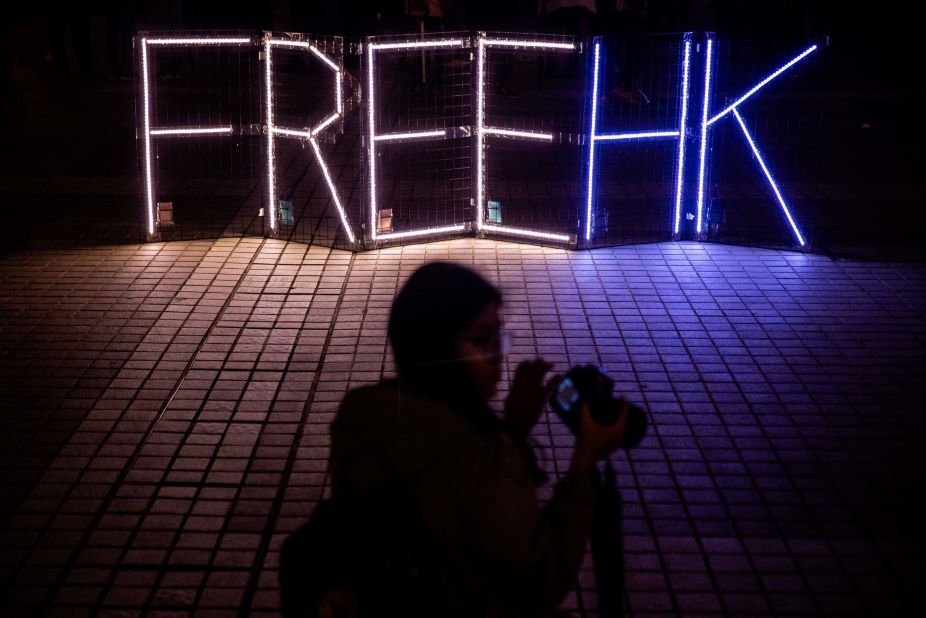 Protesters take photos of a 'Free HK' light display at a gathering in the Central district of Hong Kong on December 30.