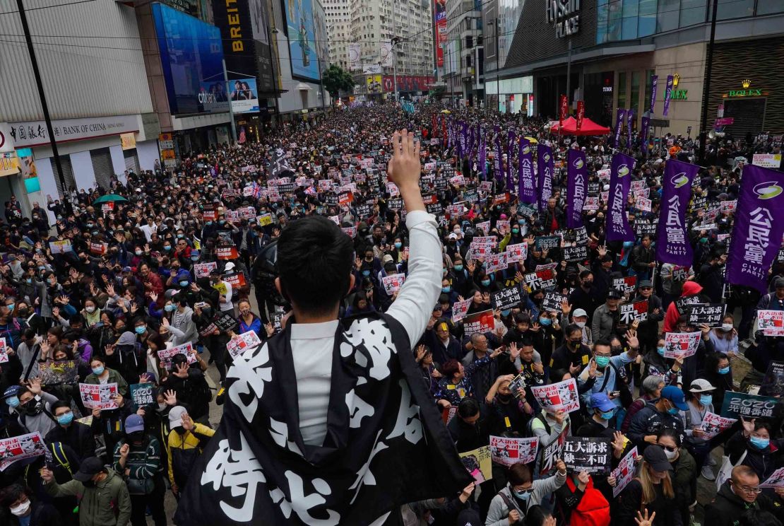 A Hong Kong protestor shows a five demands gesture, during a march on Wednesday. 