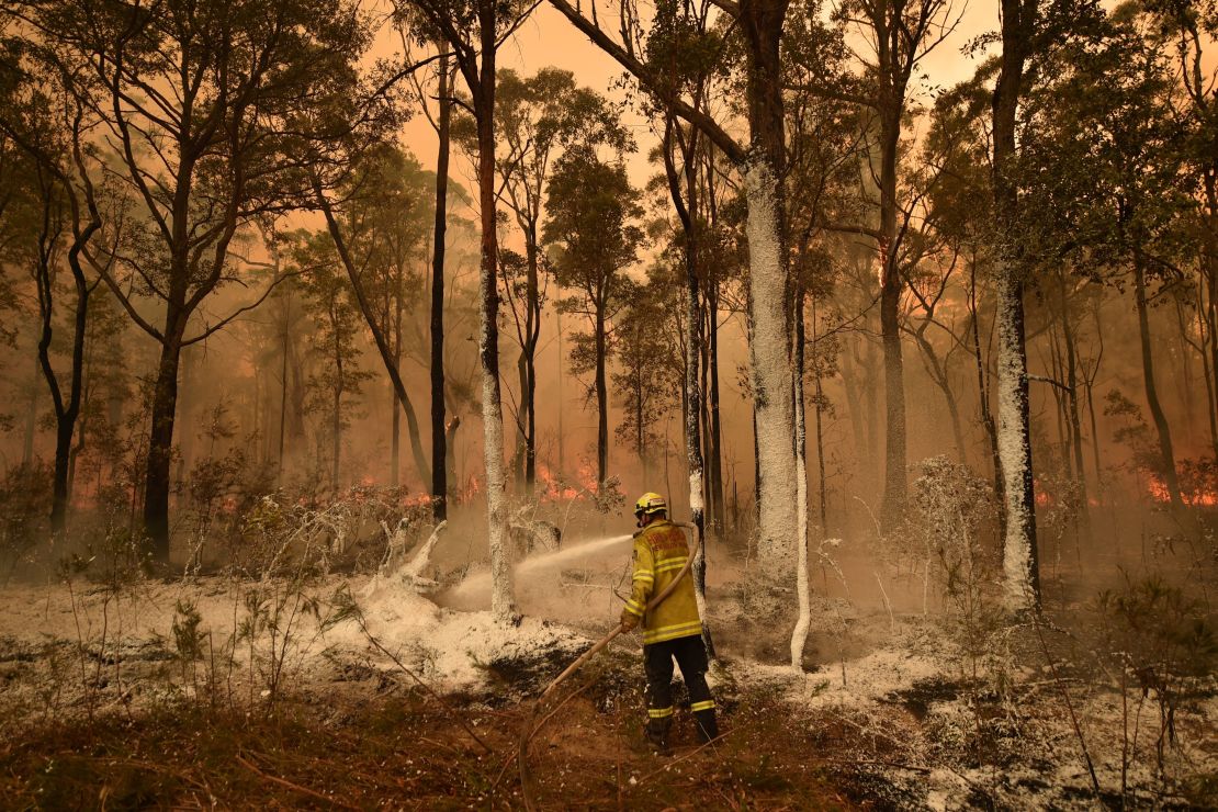 A firefighter sprays foam retardant ahead of a fire front in the New South Wales town of Jerrawangala on January 1, 2020.