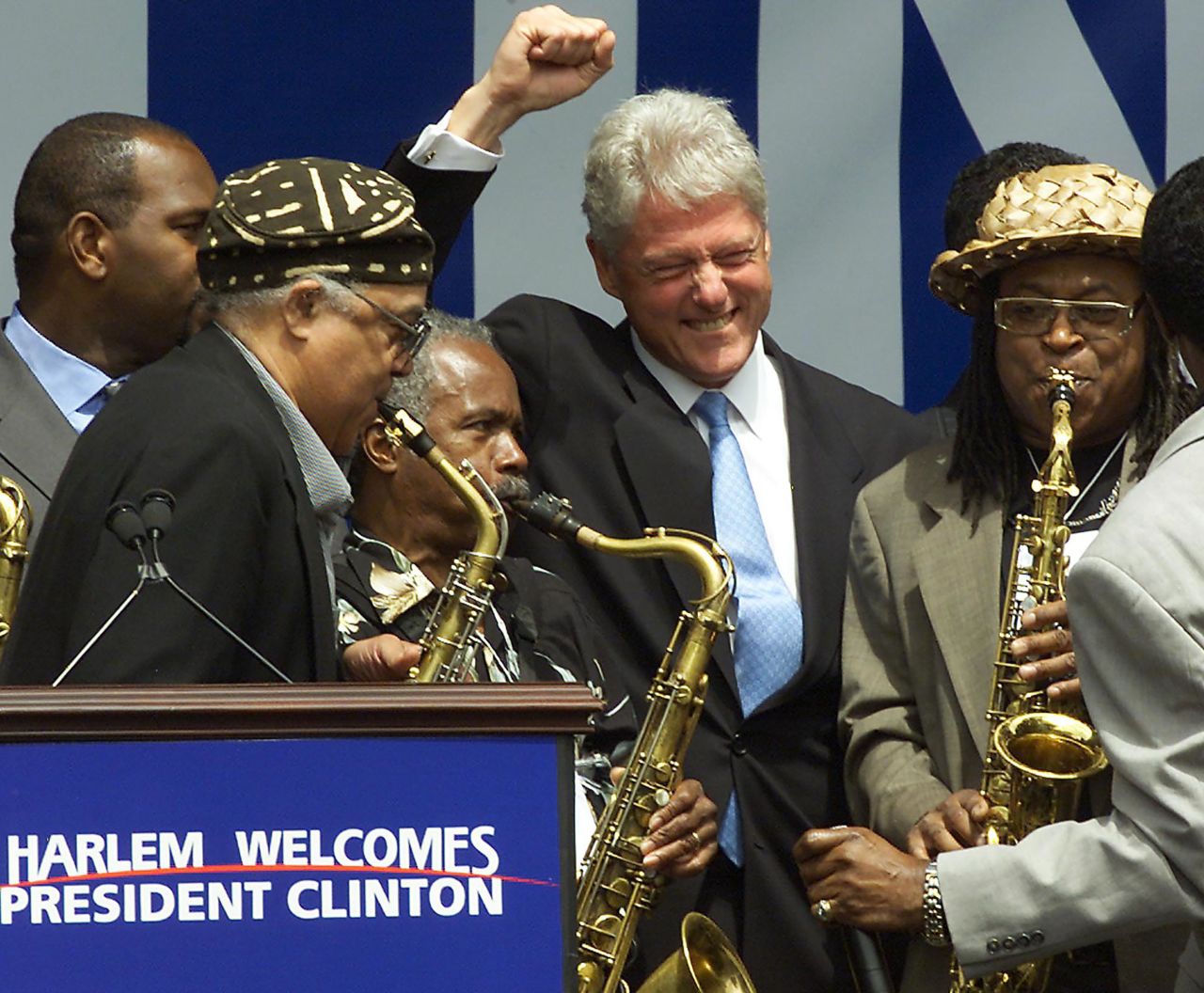 Clinton cheers a group of saxophone players at a rally in New York in July 2001. Harlem residents were welcoming Clinton, who was moving into his new post-presidential office.