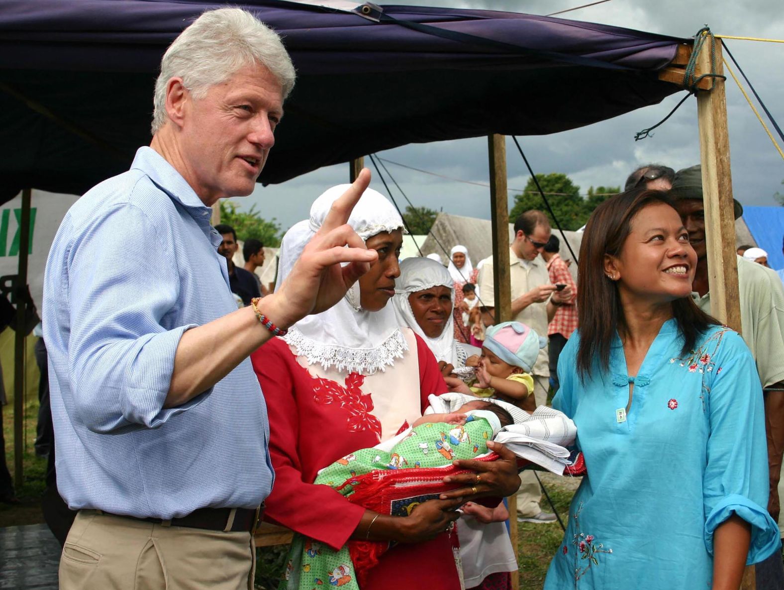 Clinton gestures as he explains to journalists that the baby being held here was born just two days earlier at a refugee camp in Jantho, Indonesia, in May 2005. Clinton was visiting ground zero of the tsunami disaster.