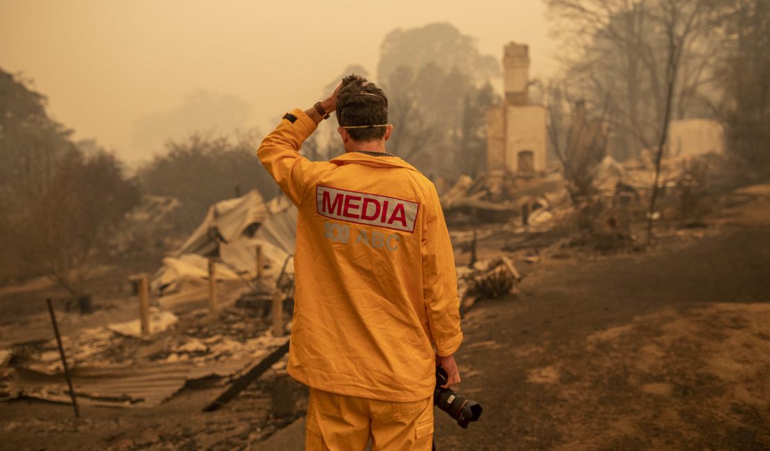 ABC photographer Matt Roberts reacts to seeing his sister's house destroyed by a bushfire in New South Wales, Australia.
