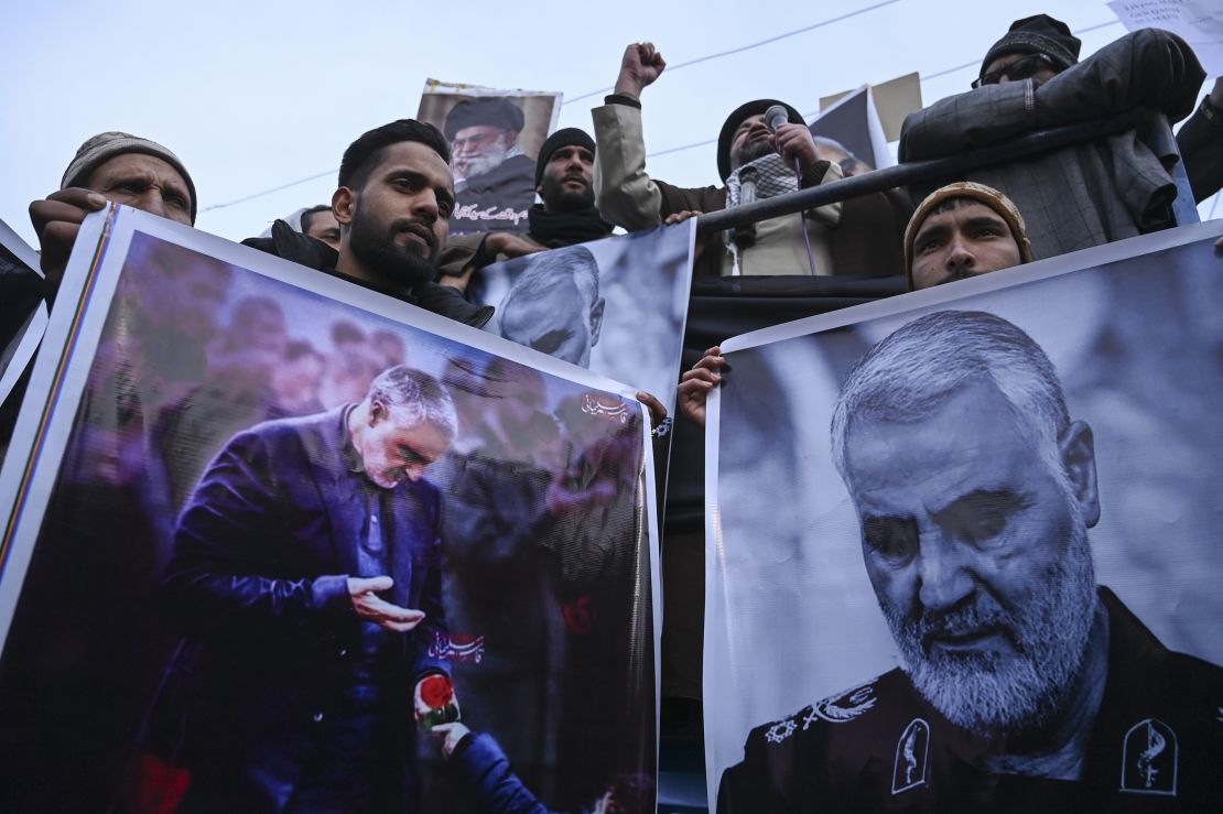 Protesters shout slogans against the United States and Israel as they hold posters with the image of Qasem Soleimani, who was killed in a US airstrike in Iraq, and Iranian President Hassan Rouhani during a demonstration in the Kashmiri town of Magam on January 3.