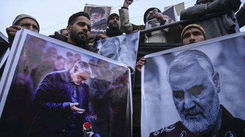 Protesters shout slogans against the United States and Israel as they hold posters with the image of Qasem Soleimani, who was killed in a US airstrike in Iraq, and Iranian President Hassan Rouhani during a demonstration in the Kashmiri town of Magam on January 3.
