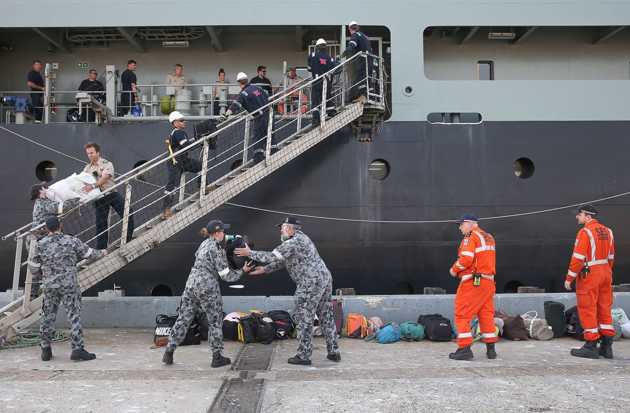A Royal Australian Navy crew unload luggage as evacuees from Mallacoota arrive aboard the MV Sycamore on January 4 at the port of Hastings, Australia.